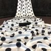 Close-up of smooth white satin fabric with black dots