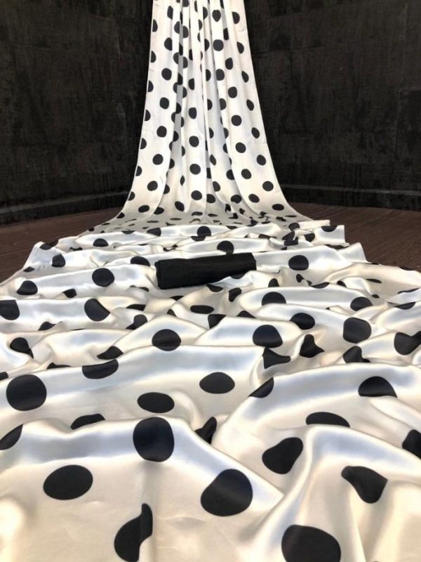 Close-up of smooth white satin fabric with black dots