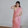 Woman wearing peach organza saree with golden butta – festive traditional wear