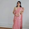 Woman wearing peach organza saree with golden butta – festive traditional wear