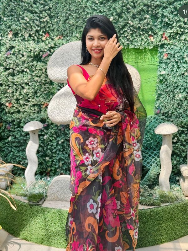 Woman wearing black floral organza saree with vibrant flower prints – festive and party wear